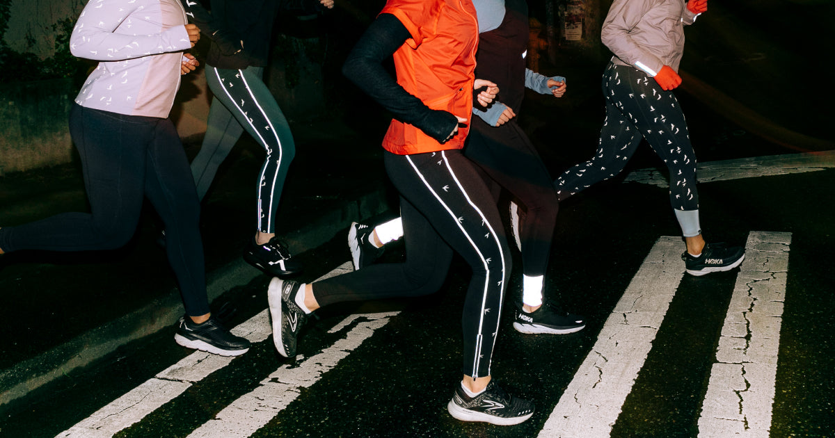Group of women running at night in Oiselle reflective gear