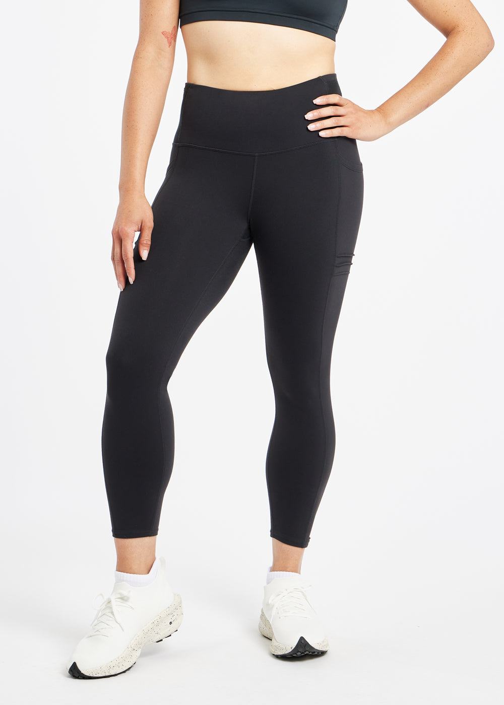 Woman wearing black compression tights in size 4, front view