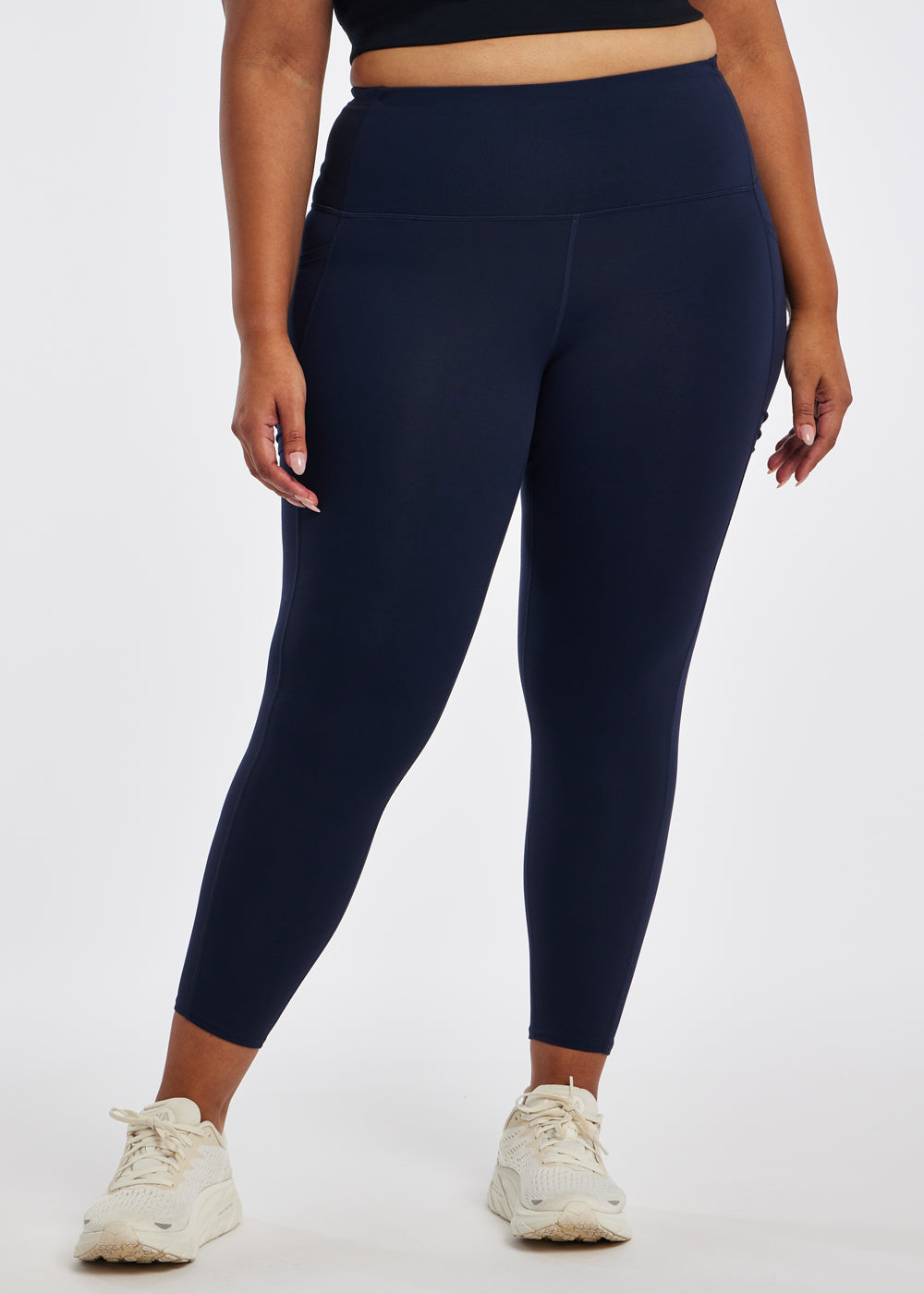 Woman wearing dark blue compression tights in size 16/18, front view