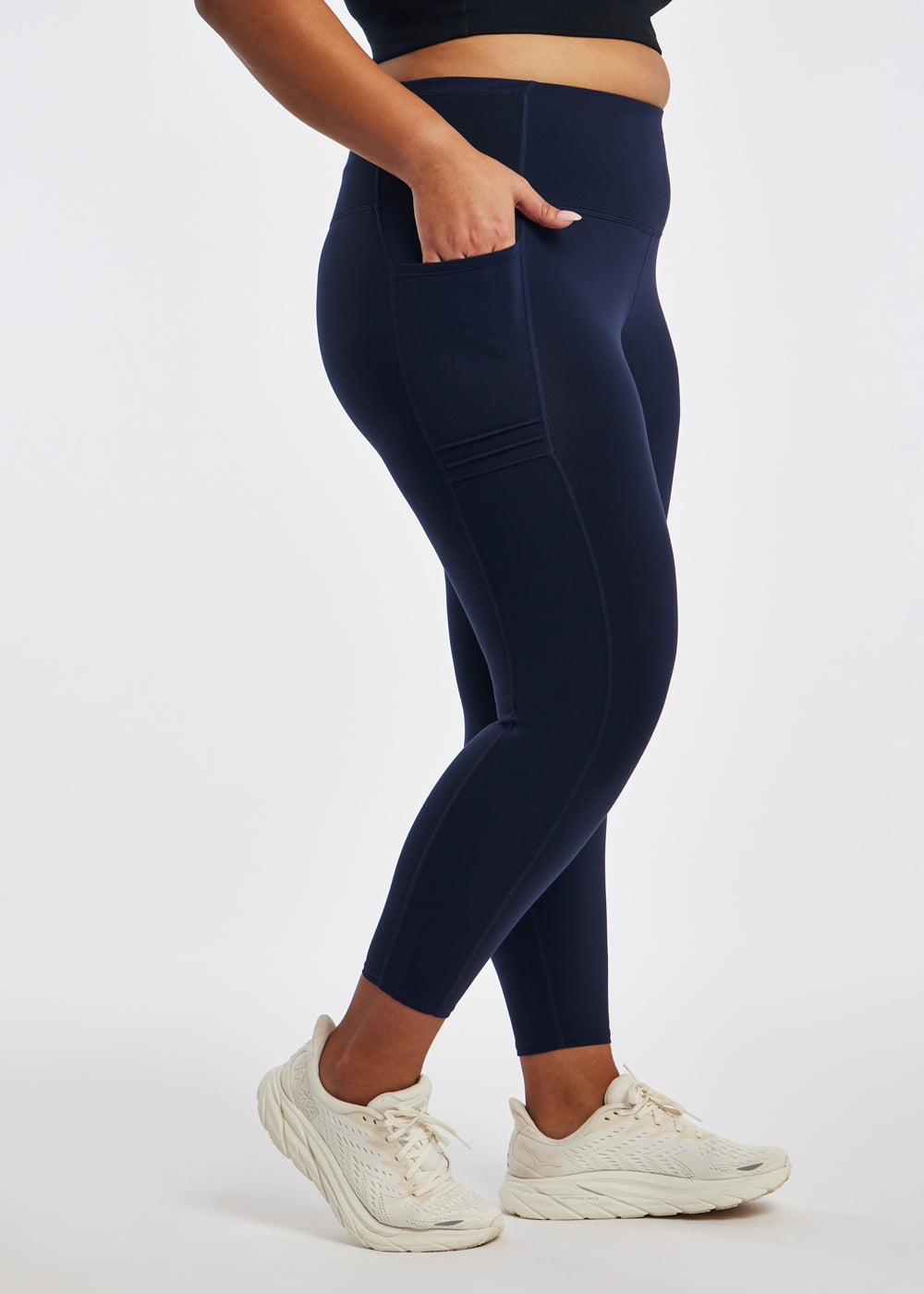 Woman wearing dark blue compression tights in size 16/18, side view