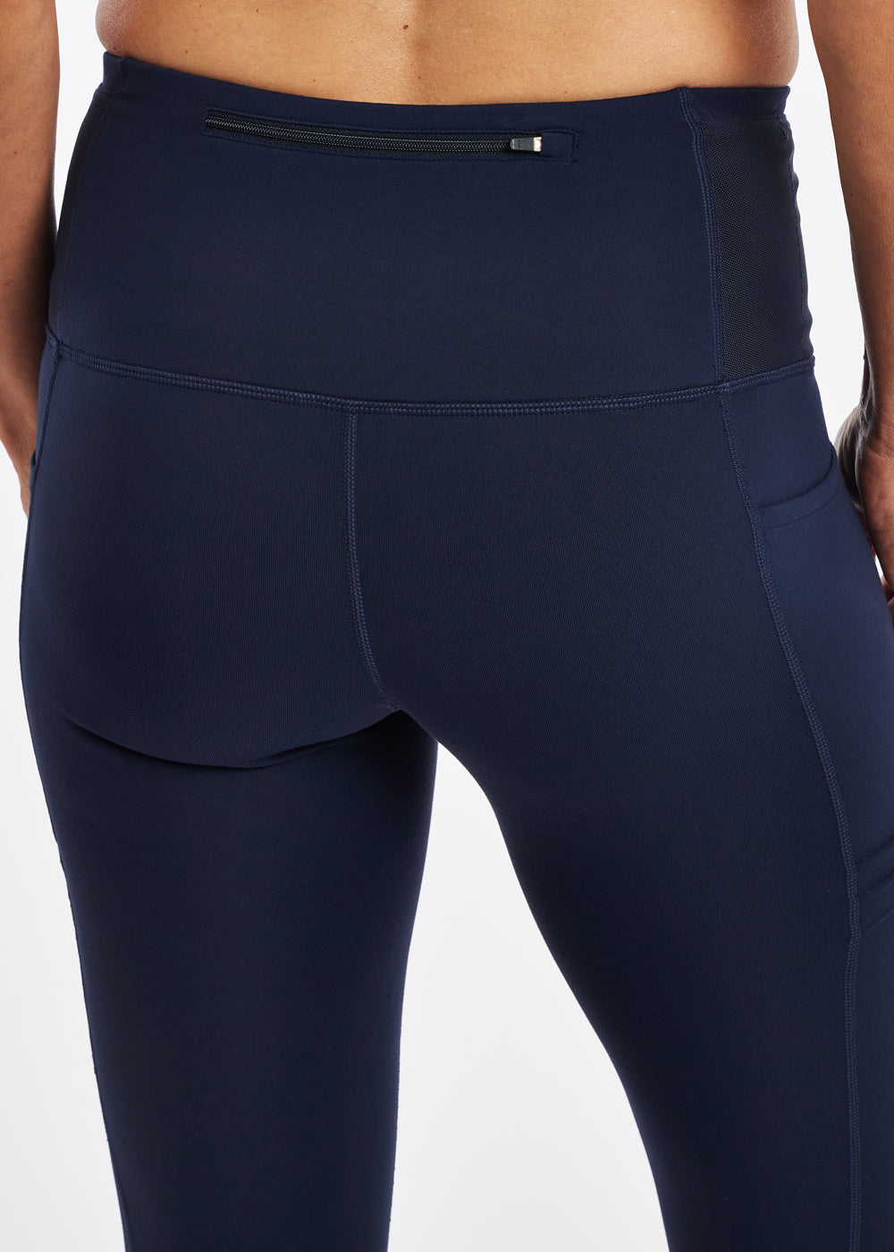 Woman wearing dark blue compression tights, close up back zipper pocket